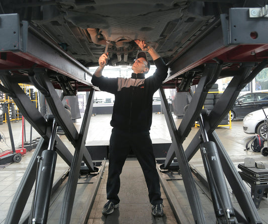 Mechanic Working on a Car on a Lift